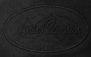 Close-up of a black woven textile with an oval embroidered logo reading 'Viesto  Classics' in tonal black thread.
